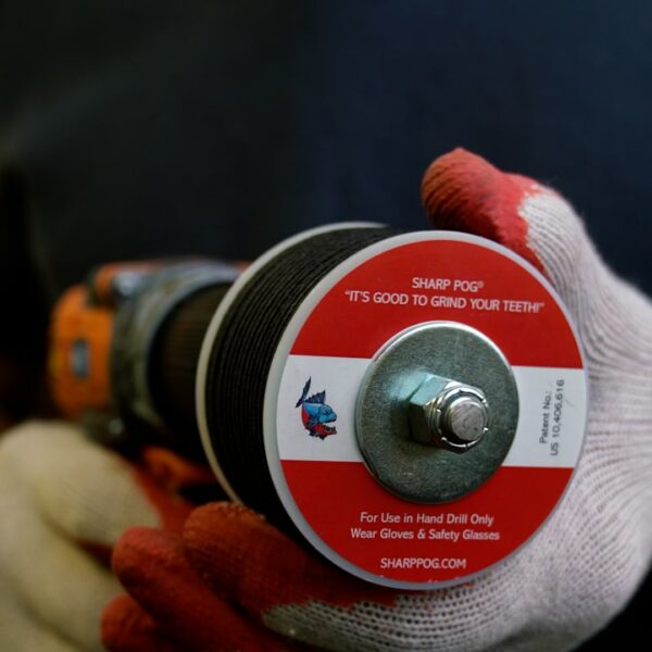 Gloved hand attaching sharpener to power drill